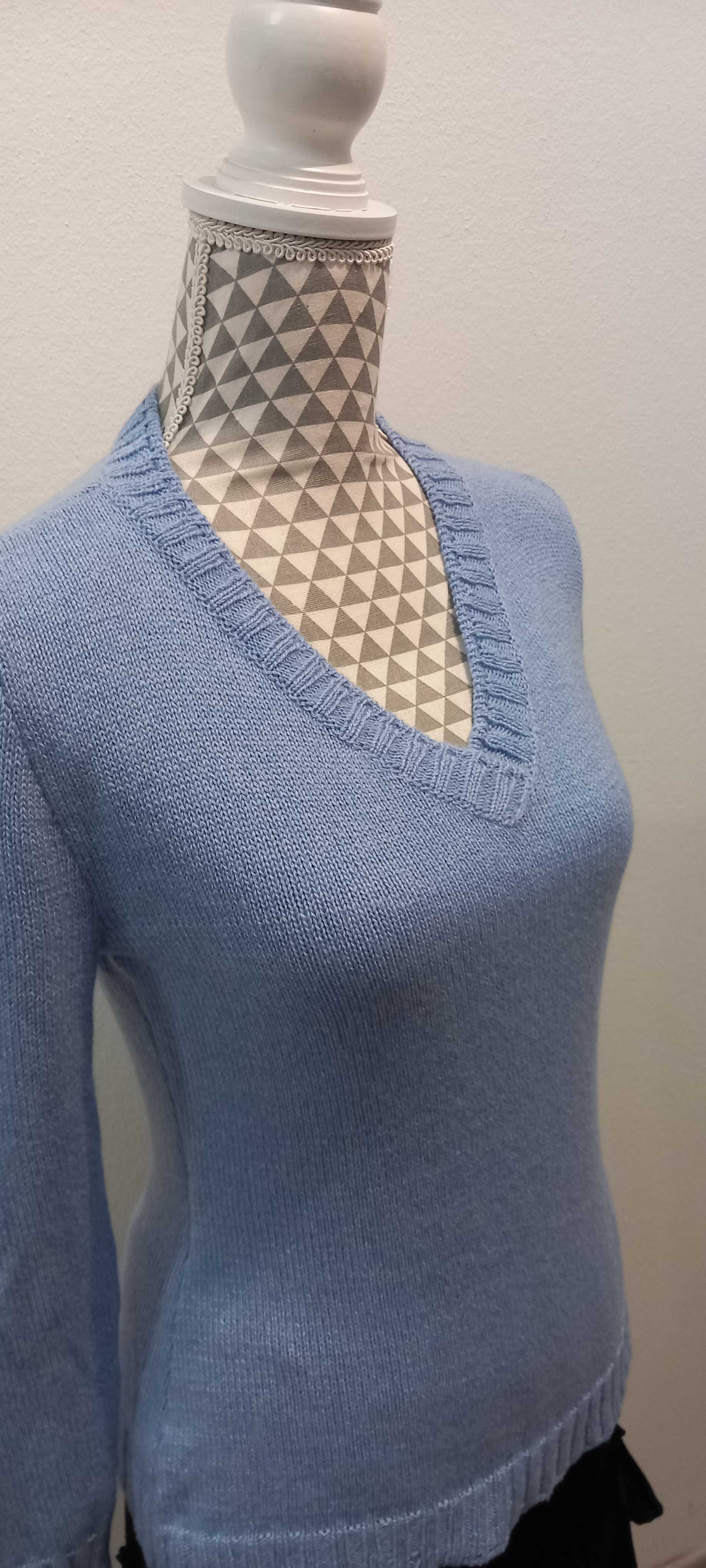maglione azzurro con scollo a v in cashmere indossato da un manichino
